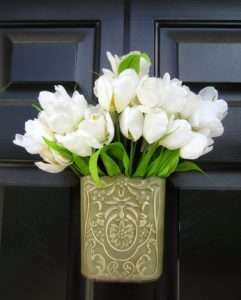 δοχειο με λουλουδια κρεμασμενο σε πορτα