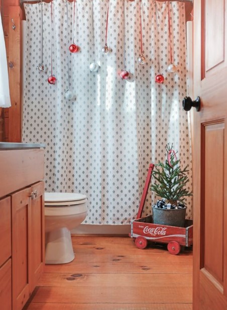 χριστουγεννιάτικες μπάλες κρεμασμένες στη κουρτίνα του μπάνιου