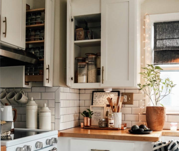 Κουζίνα με άσπρα ντουλάπια, ξύλινος πάγκος κουζίνας, άσπρα πλακάκια κουζίνας