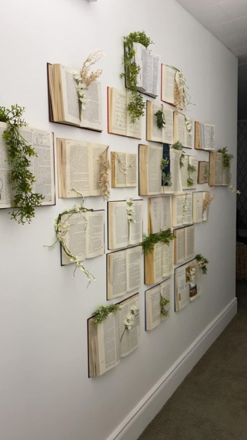 διακοσμημένος τοίχος με ανοιχτά βιβλία και φυτά
