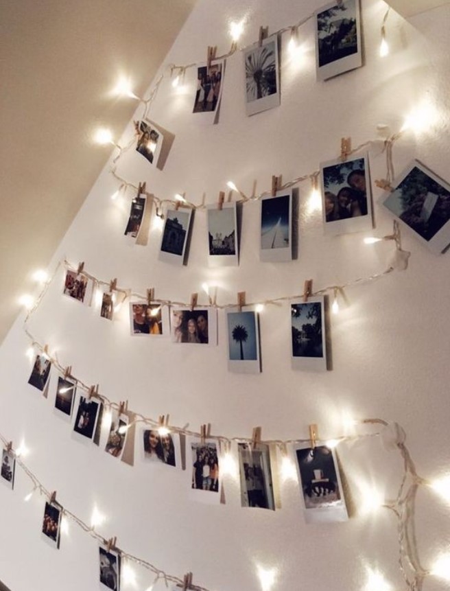 φωτογραφίες στον τοίχο κρεμασμένες με φωτάκια και μανταλάκια